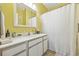 Clean bathroom with white cabinets, yellow walls, and a white shower curtain at 4924 Pond Shoals Ct. # 101, Myrtle Beach, SC 29579