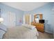 Bedroom with blue walls, a bed, dresser, and a door to another room at 4924 Pond Shoals Ct. # 101, Myrtle Beach, SC 29579