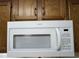 Clean white microwave oven in a kitchen with wood cabinets at 5001 Little River Rd. # W109, Myrtle Beach, SC 29577