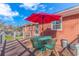 Back patio with seating, red umbrella, and brick exterior at 5080 Forest Dr., Loris, SC 29569