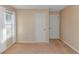 Empty bedroom with carpeted floors, two white doors, and a large window at 5080 Forest Dr., Loris, SC 29569