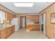 Kitchen featuring ample wooden cabinetry, white appliances, and linoleum flooring at 5080 Forest Dr., Loris, SC 29569