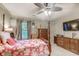 Bedroom with pink floral bedspread, wooden furniture, and a wall-mounted TV at 604 Stableford Ct., Myrtle Beach, SC 29577