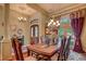Formal dining space with chandelier, wood table and chairs, and large curtained windows at 604 Stableford Ct., Myrtle Beach, SC 29577