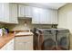 Laundry room with white cabinets, utility sink, and front-loading washer and dryer at 604 Stableford Ct., Myrtle Beach, SC 29577