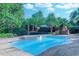 Inviting backyard oasis featuring a sparkling pool with a hot tub, fireplace, and lush landscaping at 604 Stableford Ct., Myrtle Beach, SC 29577