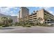 Exterior view of a high-rise condo building with parking garage and lush landscaping at 9994 Beach Club Dr. # 1604, Myrtle Beach, SC 29572