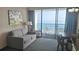 Living room with ocean view, balcony access, couch, and dining area at 1105 S Ocean Blvd. # 830, Myrtle Beach, SC 29577