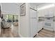 View of the kitchen from the hallway showcasing white appliances and wood-look flooring at 415 Ocean Creek Dr. # 2236, Myrtle Beach, SC 29572