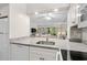 Modern kitchen with white cabinets, granite counters, stainless steel appliances, and open view to living area at 415 Ocean Creek Dr. # 2236, Myrtle Beach, SC 29572