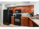 Modern kitchen with wood cabinets and black appliances at 5300 N Ocean Blvd. # 1011, Myrtle Beach, SC 29577