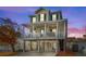 Twilight view of beach home exterior with two balconies, driveway, and stilt foundation at 6001 - 5326 S Kings Hwy., Myrtle Beach, SC 29575