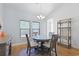 Bright dining room features a glass-top table and four chairs, along with a wooden shelving unit at 865 Summer Starling Pl., Myrtle Beach, SC 29577
