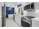 Modern kitchen with white cabinets, blue walls, and stainless steel appliances at 1029 Old Plantation Dr., Pawleys Island, SC 29585