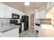 Galley-style kitchen with white cabinets, granite countertops, and black appliances at 422 Nature Trail Dr., Little River, SC 29566