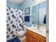 Clean bathroom with shower/tub combo, wood vanity, and blue accents at 5804 Longwood Dr. # 301, Murrells Inlet, SC 29576