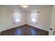 Well-lit bedroom with hardwood floors and two windows at 90 Wateree Trail, Georgetown, SC 29440