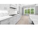 Modern kitchen features white cabinets, geometric backsplash, and quartz countertops at 1017 Muscovy Pl., Conway, SC 29526