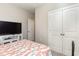Bright bedroom with a TV, double doors, and a bed with coral bedding at 5037 Sassari St., Myrtle Beach, SC 29579