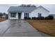 White house with gray roof, landscaping, and a driveway at 957 Bellflower Dr., Longs, SC 29568