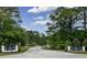 Hunters Trace entrance with lush landscaping and paved road at 1050 Harbor Dr., Calabash, NC 28467