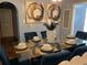 Elegant dining room featuring a glass table, blue velvet chairs, and stylish artwork at 410 Pearl St., Conway, SC 29527