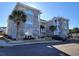 Brick condo building with arched windows and palm trees in front at 4717 Wild Iris Dr. # 29-303, Myrtle Beach, SC 29577