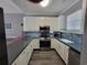Modern kitchen with white cabinets, gray countertops, and stainless steel appliances at 4717 Wild Iris Dr. # 29-303, Myrtle Beach, SC 29577