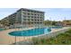 Community pool with lounge chairs and building view at 5907 South Kings Hwy. # 308, Myrtle Beach, SC 29575