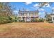 Two-story house with front porch, mature trees, and a spacious yard at 6011 Dick Pond Rd., Myrtle Beach, SC 29588
