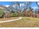 Backyard with a large tree and a winding concrete pathway at 6011 Dick Pond Rd., Myrtle Beach, SC 29588