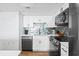 Modern kitchen with white cabinets, stainless steel appliances, and blue tile backsplash at 1210 N Waccamaw Dr. # 404, Garden City Beach, SC 29576
