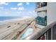Balcony view of beach, ocean, and resort pool below at 1210 N Waccamaw Dr. # 404, Garden City Beach, SC 29576