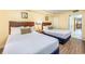 Two double beds in a condo bedroom with wood floors and access to a balcony at 201 77Th Ave. N # 923, Myrtle Beach, SC 29572