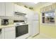 White kitchen with gas range, refrigerator, and window overlooking parking lot at 4633 Lightkeepers Way # 5-C, Little River, SC 29566