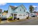 Two-story light blue house with a double garage, landscaping, and driveway at 4739 Cloisters Ln., Myrtle Beach, SC 29577