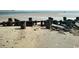 View of sandy beach with old wooden posts and rocks at 598 Blue Stem Dr. # 52D, Pawleys Island, SC 29585