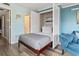 Small bedroom with a murphy bed and teal walls, maximizing space at 7500 Ocean Blvd. N # 6010, Myrtle Beach, SC 29572