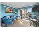 Living room with teal walls, comfortable seating, and balcony access at 7500 Ocean Blvd. N # 6010, Myrtle Beach, SC 29572