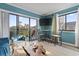 Living area features a teal accent wall, balcony access, and a dining area at 7500 Ocean Blvd. N # 6010, Myrtle Beach, SC 29572
