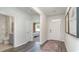 Light-filled entryway with wood-look floors and view to bedroom and bathroom at 1180 Maxwell Dr., Little River, SC 29566