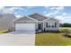 Gray exterior of charming one-story house with a two-car garage and landscaped lawn at 202 Carver Willow Dr., Loris, SC 29569