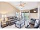 Living room with vaulted ceiling, leather furniture, and access to balcony at 400 Blue Stem Dr. # 60-E, Pawleys Island, SC 29585