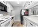 White kitchen cabinets, black appliances, and granite countertops at 609 Hillside Dr. S # D-17, North Myrtle Beach, SC 29582