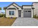 Modern home with gray garage and a brick paved driveway at 6703 Ocean Breeze Loop, Myrtle Beach, SC 29577