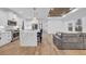 Open floor plan with white kitchen, marble island, stainless steel appliances, and hardwood floors at 6703 Ocean Breeze Loop, Myrtle Beach, SC 29577