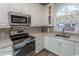 Modern white kitchen with stainless steel appliances and granite counters at 690 Riverwalk Dr. # 201, Myrtle Beach, SC 29579