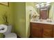 Small bathroom with wooden vanity and light green walls at 702 Plantation Dr., Surfside Beach, SC 29575