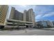 Oceanfront building, multiple stories, parking area, and palm trees at 501 S Ocean Blvd. # 601, North Myrtle Beach, SC 29582