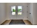 Bright entryway with double white doors, wood-look flooring, and a dark gray welcome mat at 329 Spinney Dr., Little River, SC 29566